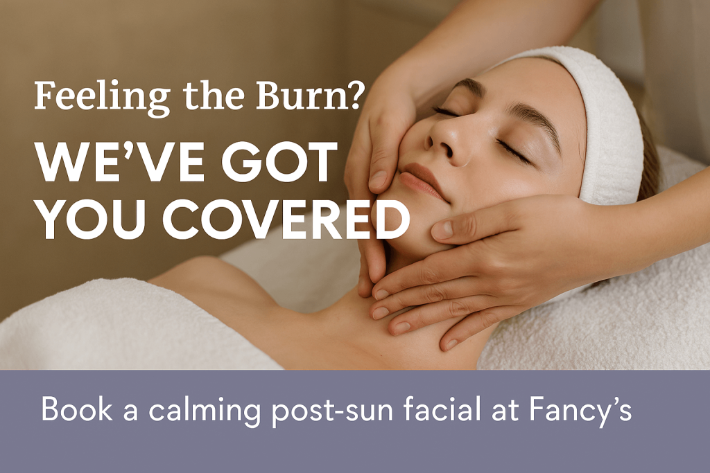 A woman lies on a spa table with eyes closed as an esthetician gently massages her face during a facial. Text reads “Feeling the Burn? We’ve Got You Covered” and “Book a calming post-sun facial at Fancy’s.”